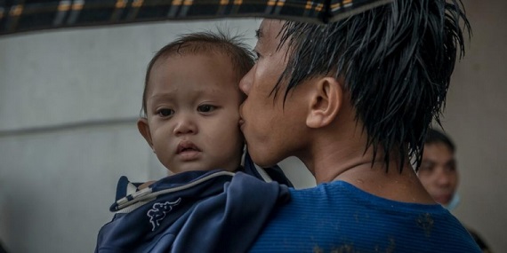 2013년 11월. 태풍 하이옌이 지나간 후 4일째 되던 날, 타클로반 시에서 한 남자가 아들에게 입을 맞추고 있다. ©Yann Libessart/MSF