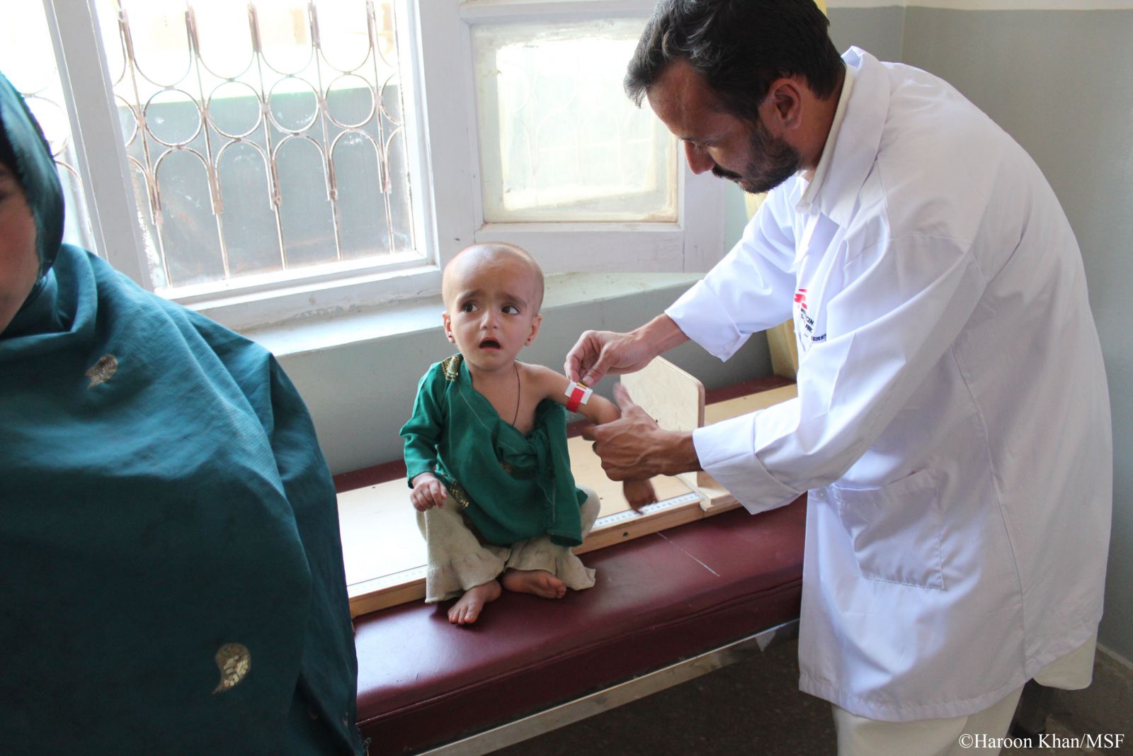 쿠람에이전시 사다병원에서 국경없는의사회 의료진이 어린아이의 위팔 둘레를 재는 방법(MUAC)을 통해 영양실조 진단을 하고 있다.