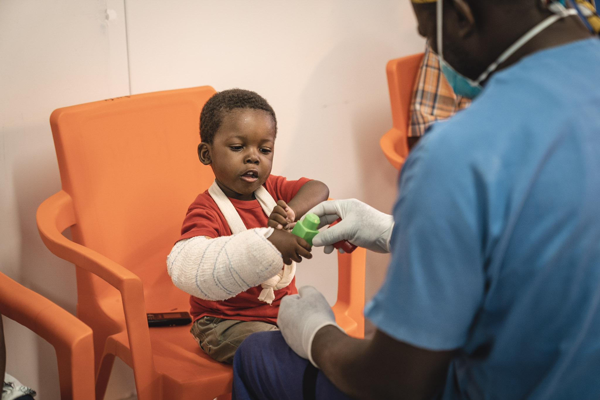 최근 아이티에서 발생한 강진으로 팔에 부상을 입은 3세 아동 오스메(Osmé)가 물리치료사와 놀고 있다. ©Pierre Fromentin/MSF