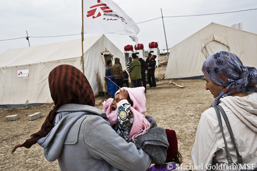 한 여성이 도미즈 캠프의 국경없는의사회 진료소에 딸을 데려오고 있다.