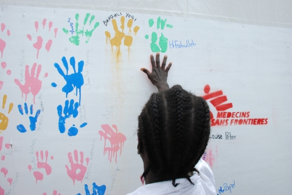 치명적인 에볼라 바이러스를 이긴 한 아동이 ‘생존자의 벽’에 손바닥 도장을 찍고 있다. 이 벽은 몬로비아에 위치한 국경없는의사회의 엘와 3 에볼라 치료센터 한쪽에 직원들이 만들어 놓은 것이다. ⓒMalin Lager/MSF