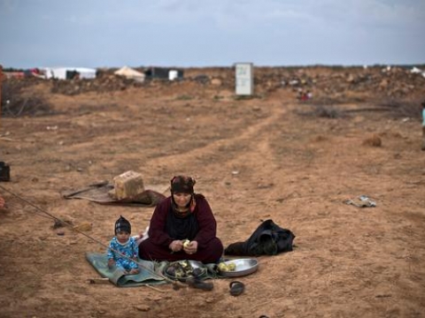 저녁 식사에 쓸 가지를 다듬는 할머니 옆에 앉아 있는 시리아 난민 아동. 이들이 앉아 있는 곳은 시리아 국경에서 가까운 요르단 마프라크 외곽에 위치한 임시 텐트촌 밖이다. ⓒHH